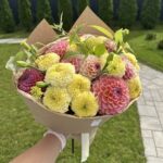 Букет из розово-желтых георгинов и крупных лимонных бархатцев в крафте
