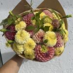 Букет из розово-желтых георгинов и крупных лимонных бархатцев в крафте